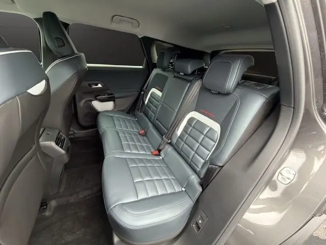 Vue intérieure côté droit des sièges arrière en cuir gris foncé de la Citroën C5 Hybride 2026 avec accoudoirs centraux.
