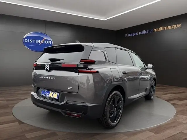 Vue 3/4 arrière droite d’un Citroën C5 Aircross gris foncé avec jantes noires et feux arrière LED distinctifs.