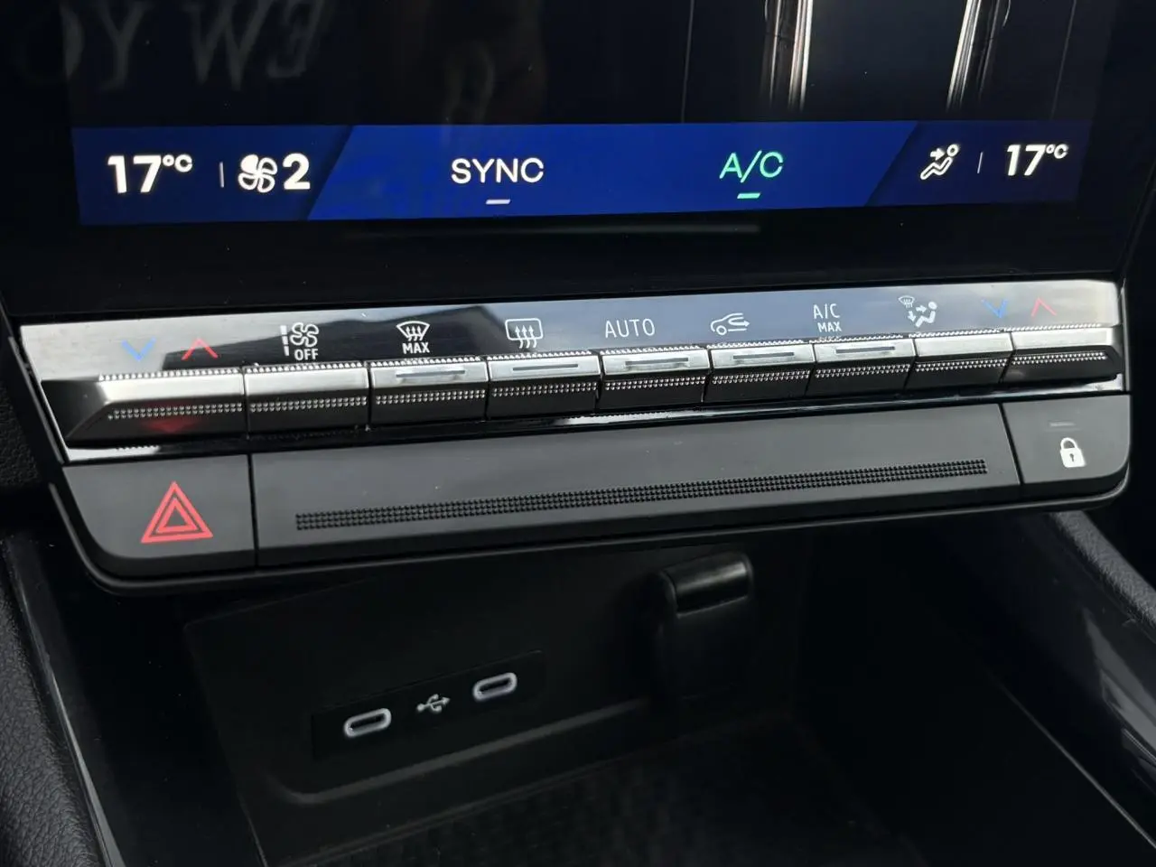 Gros plan sur la console centrale du Renault Austral E-Tech 2025, avec commandes climatisation et ports USB visibles.
