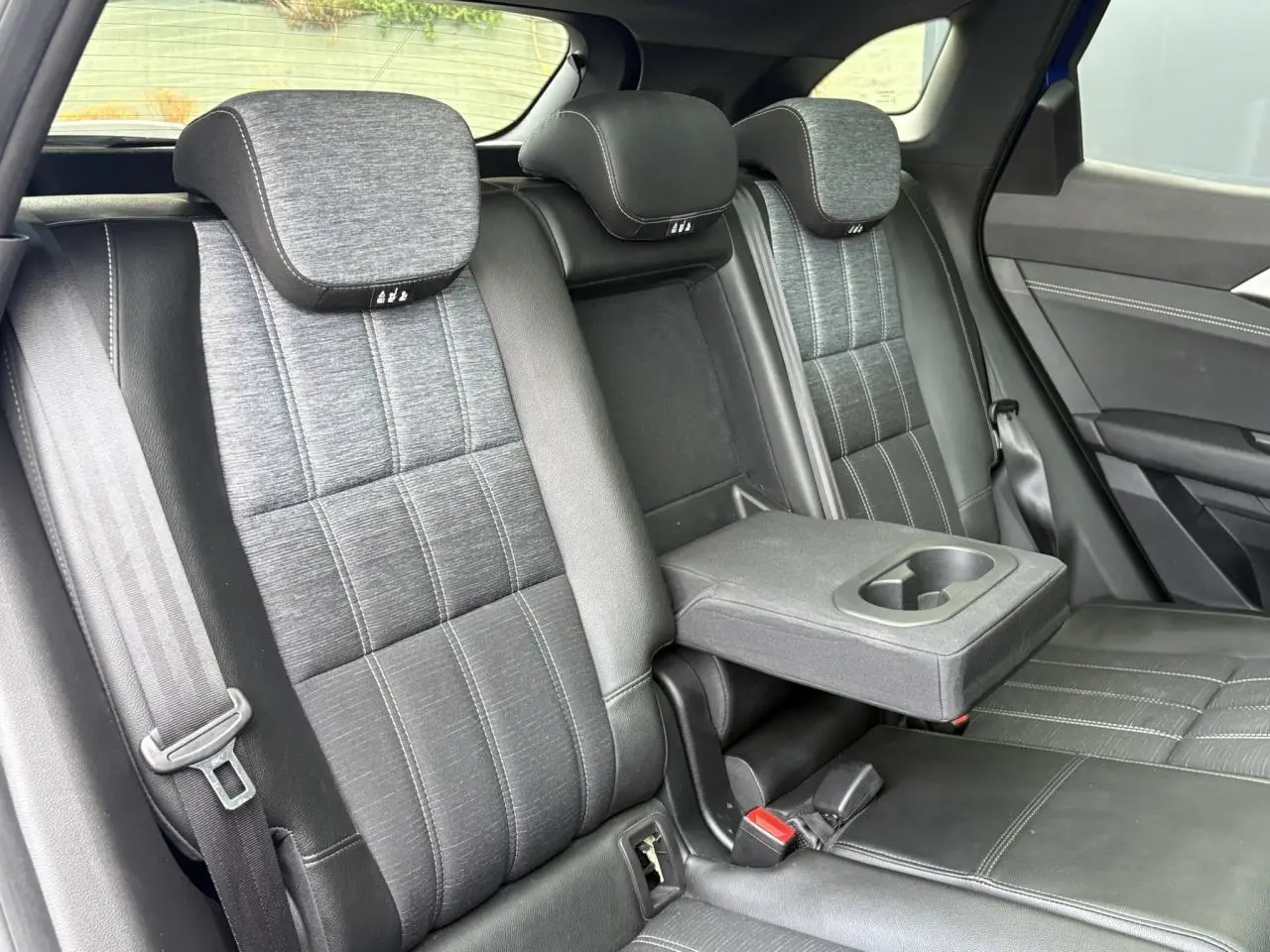 Vue intérieure de la banquette arrière du Renault Austral E-Tech, sellerie mixte gris avec accoudoir central rabattable.