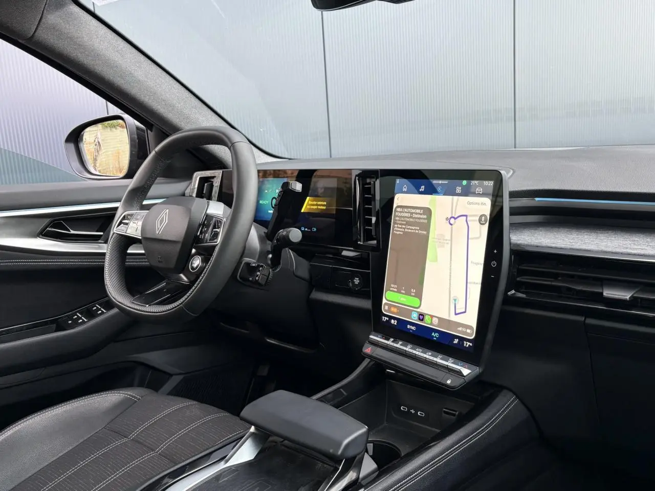 Vue intérieure côté conducteur du Renault Austral E-Tech 2025, avec grand écran tactile vertical et volant compact.