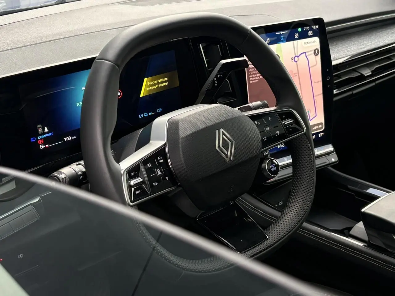 Vue rapprochée du volant noir et du tableau de bord digital du Renault Austral E-Tech 2025 avec écran tactile vertical.