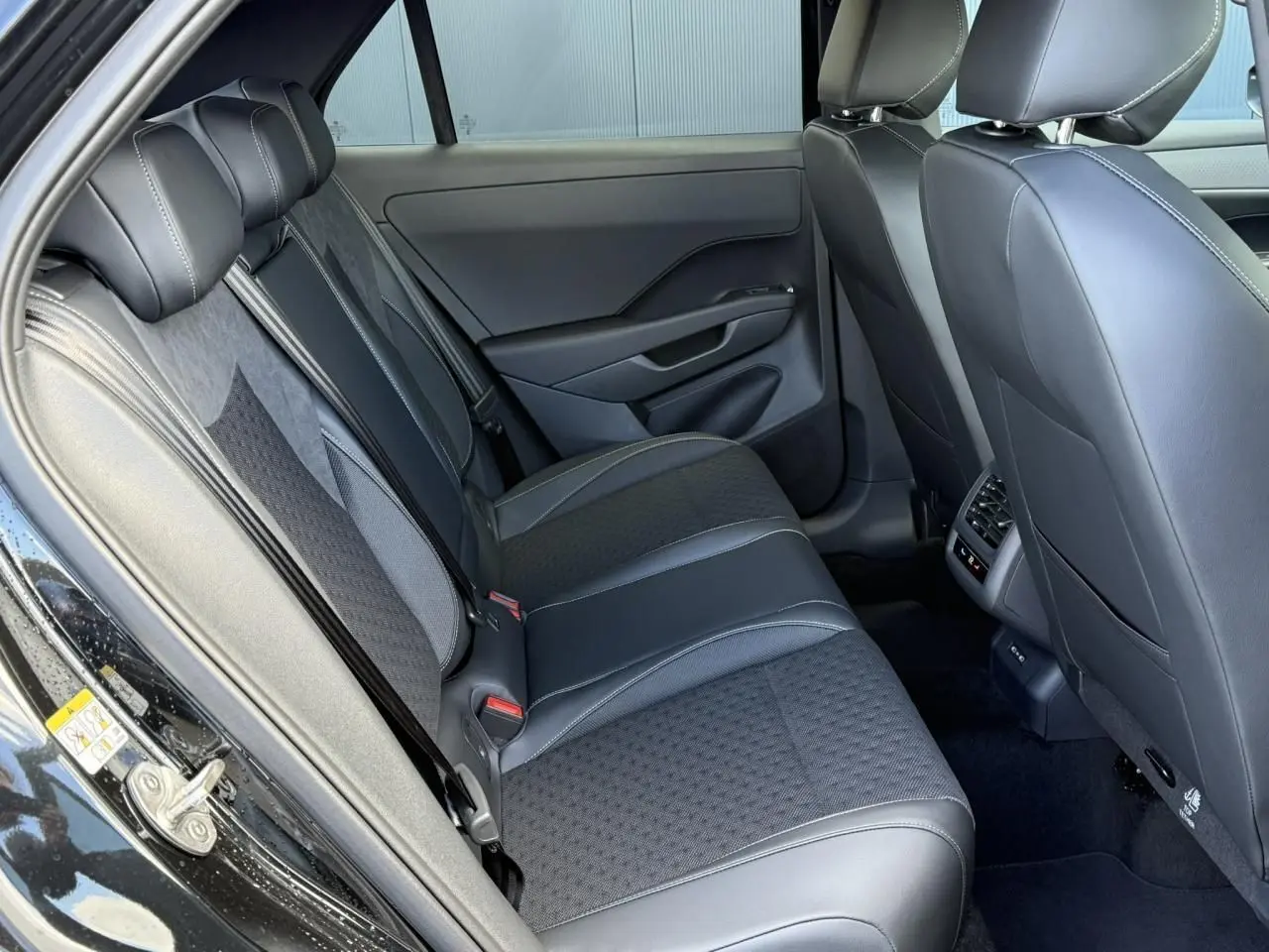 Vue intérieure côté gauche des sièges arrière en tissu et cuir noir du Volkswagen T-Roc 2026 finition R-Line.