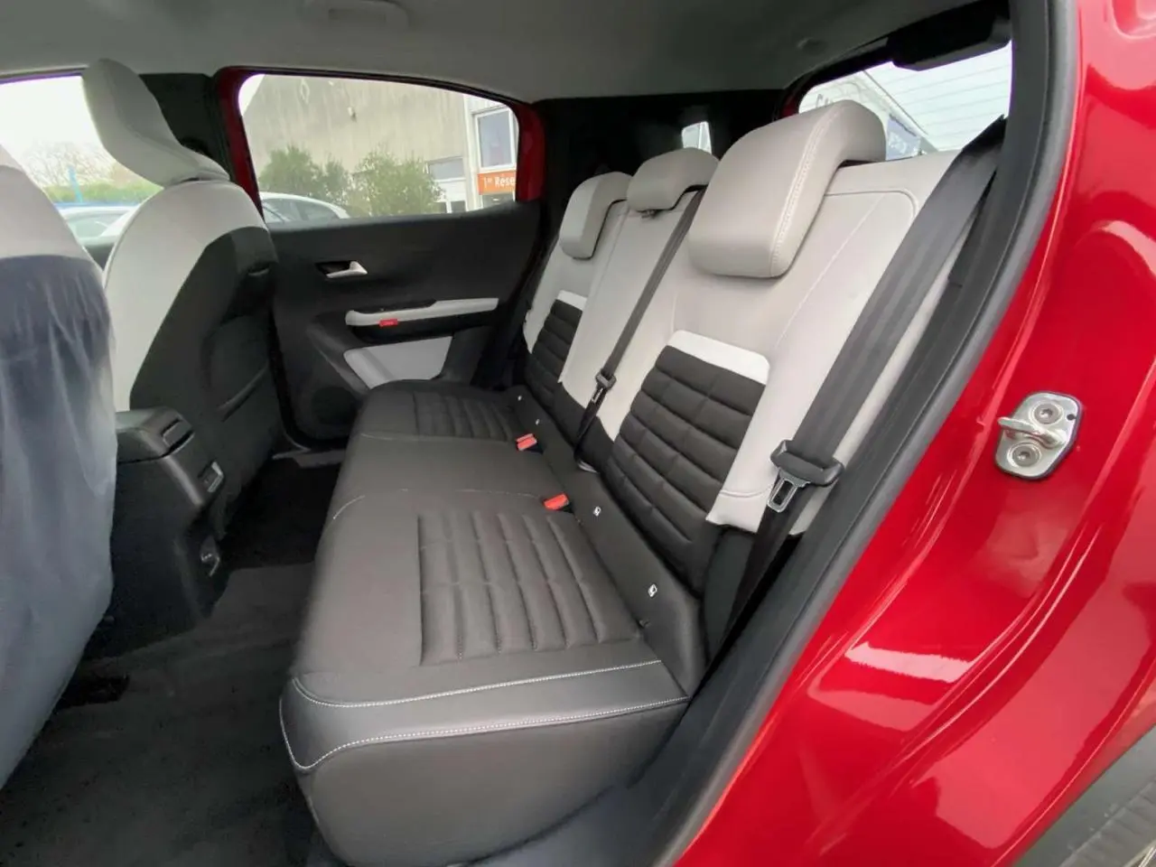 Vue intérieure côté gauche des sièges arrière en cuir bicolore noir et gris du Citroën C3 Aircross Rouge Elixir 2025.