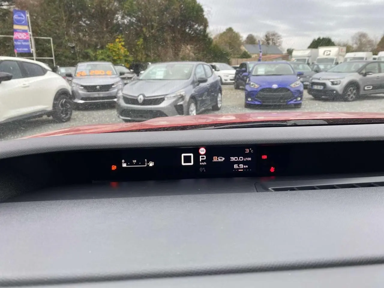 Vue intérieure du tableau de bord numérique d'une Citroën C3 Aircross rouge Elixir avec affichage multifonction.