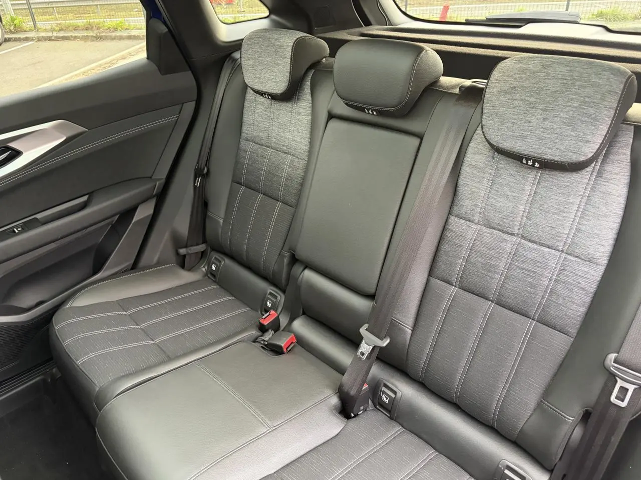 Vue intérieure côté droit sur la banquette arrière mixte tissu gris et cuir noir du Renault Austral 2025.