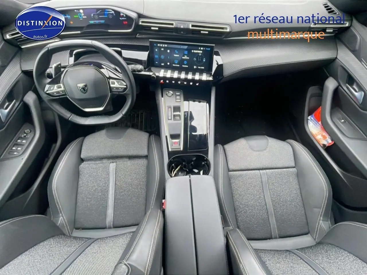 Vue intérieure frontale du poste de conduite de la Peugeot 508 SW gris artense avec volant cuir et écran tactile central.