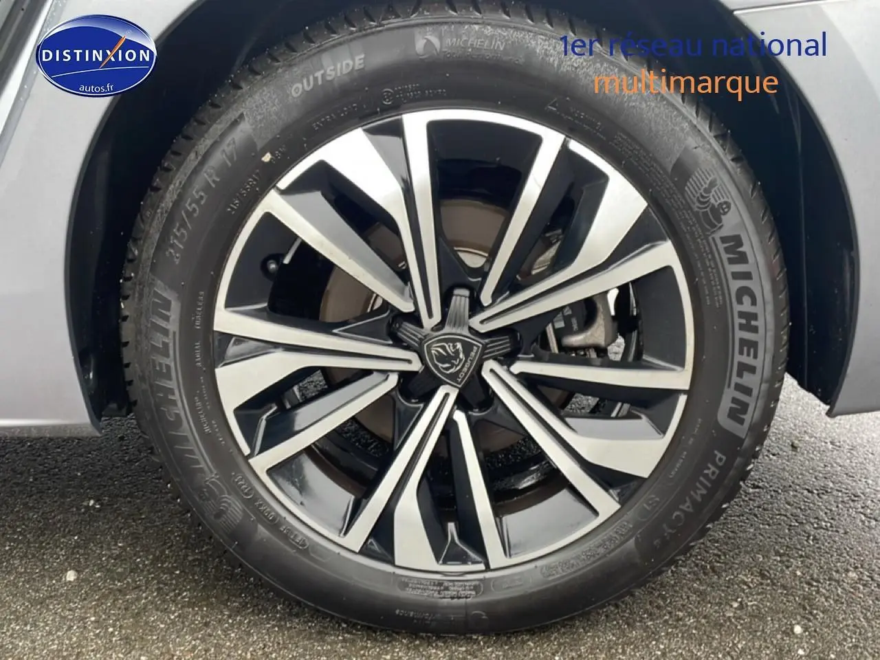 Gros plan sur la jante alu bicolore et pneu Michelin d'une Peugeot 508 SW gris Artense, côté gauche arrière.