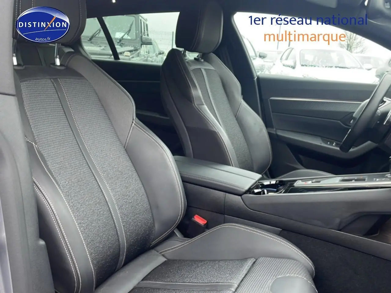 Vue intérieure côté gauche des sièges avant en tissu et cuir noir avec surpiqûres blanches d’un Peugeot 508 SW gris Artense 2024.