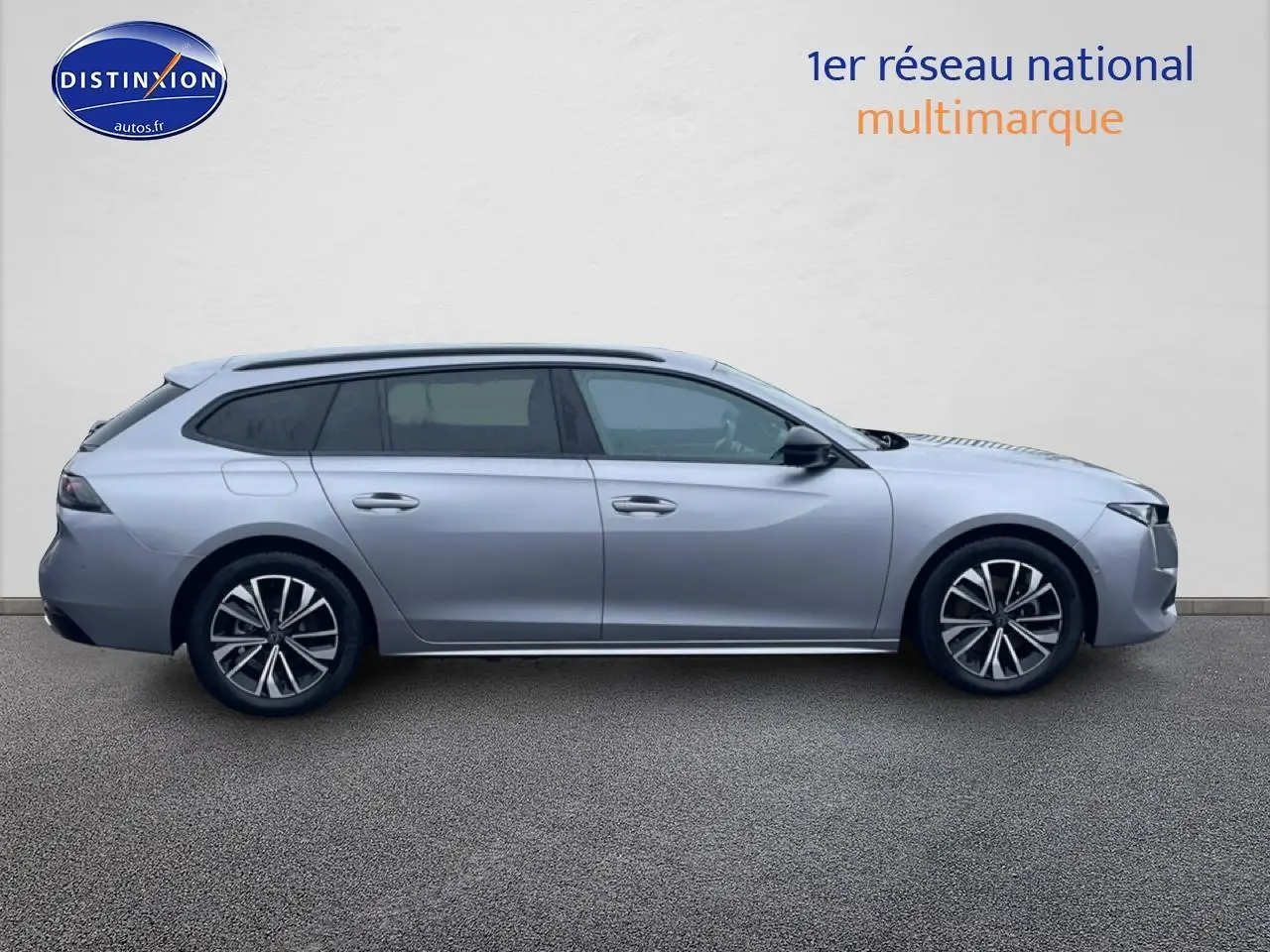 Profil droit d'une Peugeot 508 SW gris artense avec jantes alliage et barres de toit visibles.