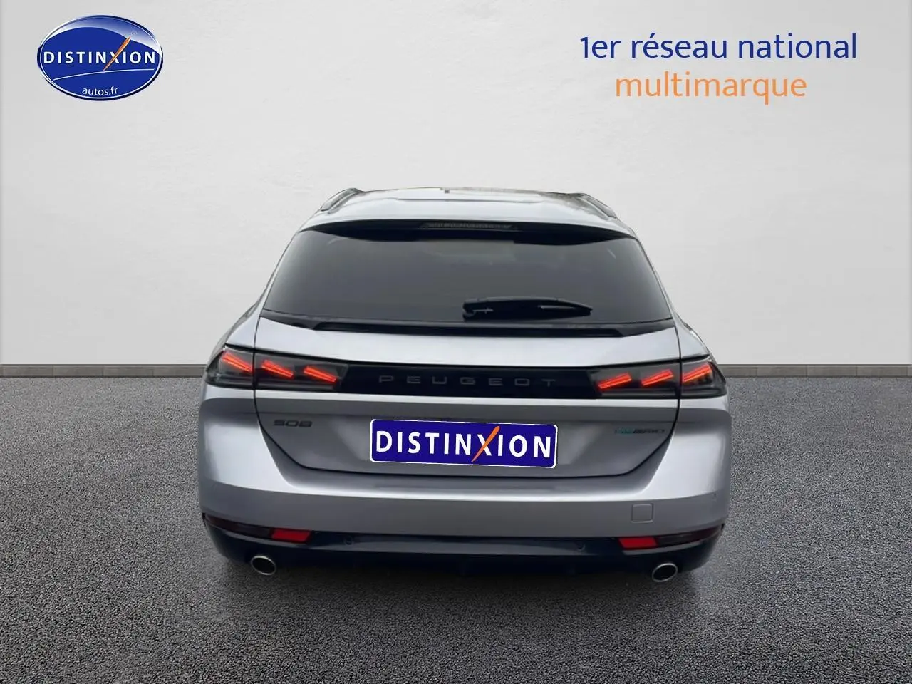 Vue arrière d'une Peugeot 508 SW gris artense avec feux LED allumés et double sortie d'échappement visible.