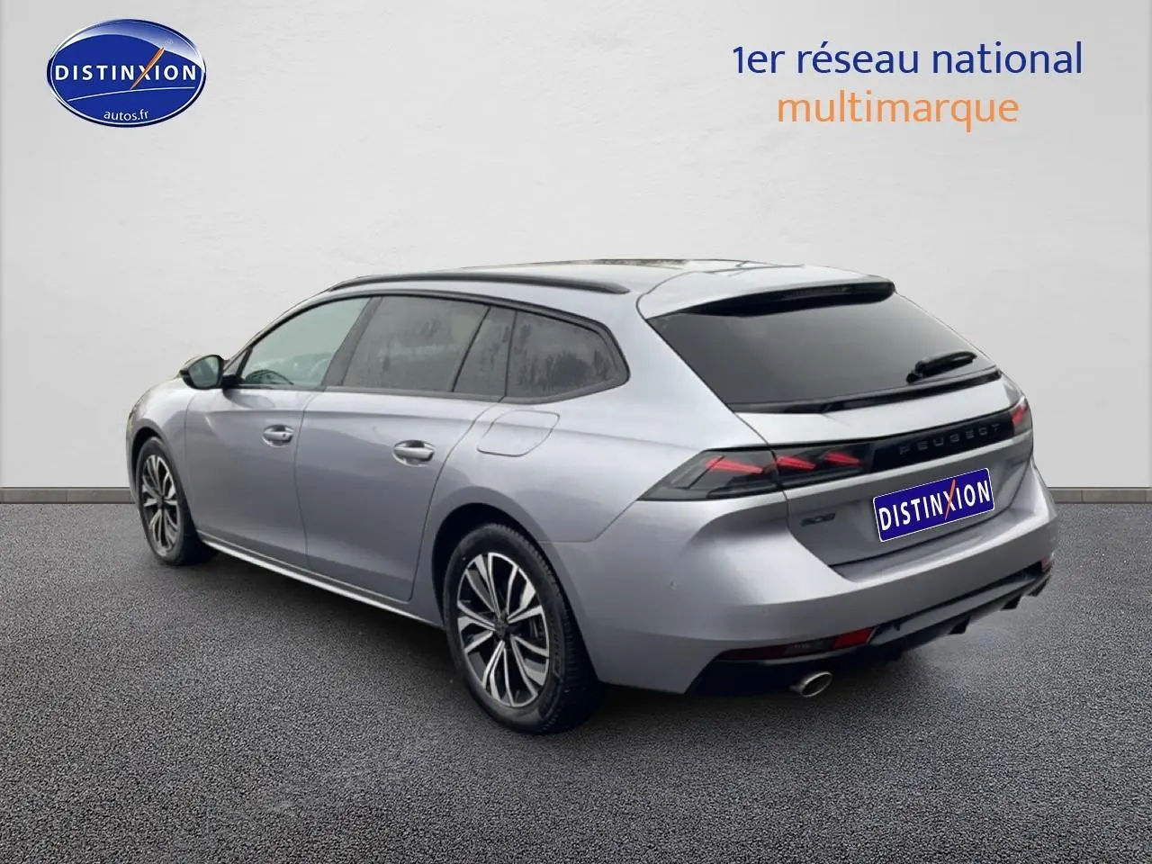 Vue 3/4 arrière droite d'une Peugeot 508 SW gris artense avec jantes alliage et vitres teintées.