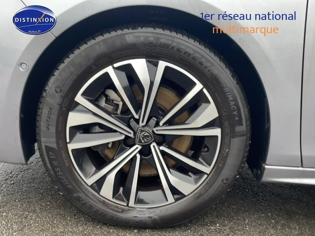 Gros plan sur la jante alu noire et argentée de la roue arrière droite d’une Peugeot 508 SW gris artense.