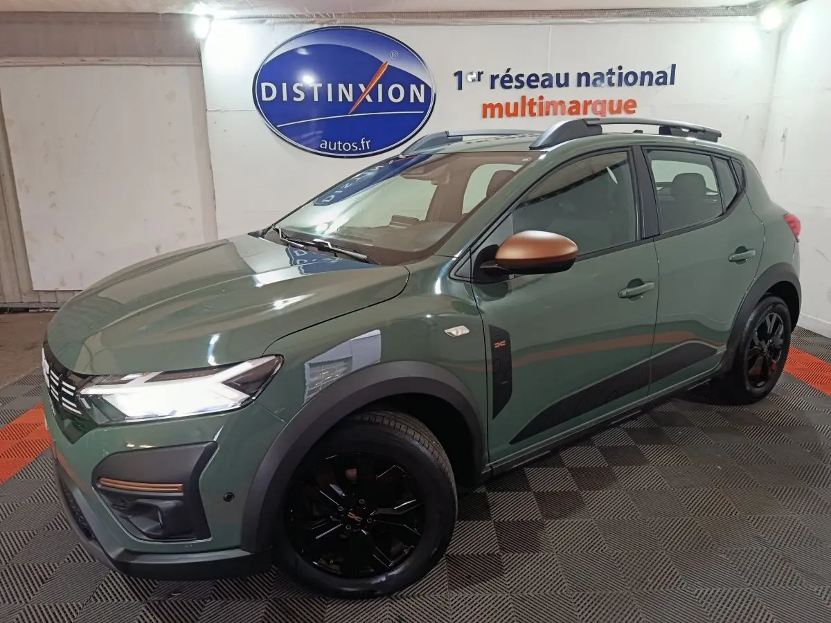 Vue 3/4 avant droite d'une Dacia Sandero Extreme+ TCe 110 2024 vert avec rétroviseurs cuivrés et jantes noires.