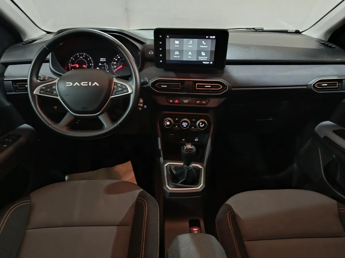 Intérieur de la Dacia Sandero Extreme+ 2024, vue frontale du tableau de bord avec écran tactile et volant noir.