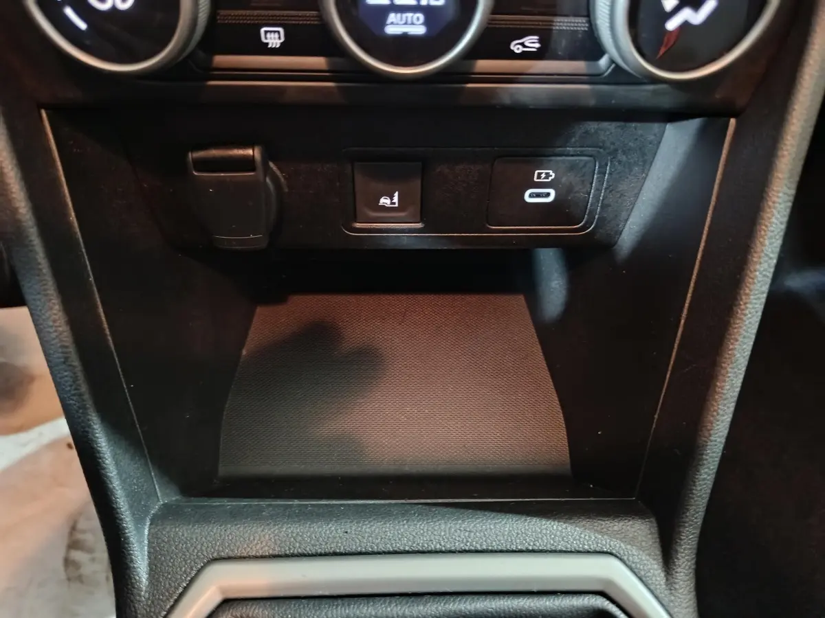 Vue rapprochée de la console centrale noire de la Dacia Sandero Extreme+ TCe 110 avec prises USB et bouton de commande.