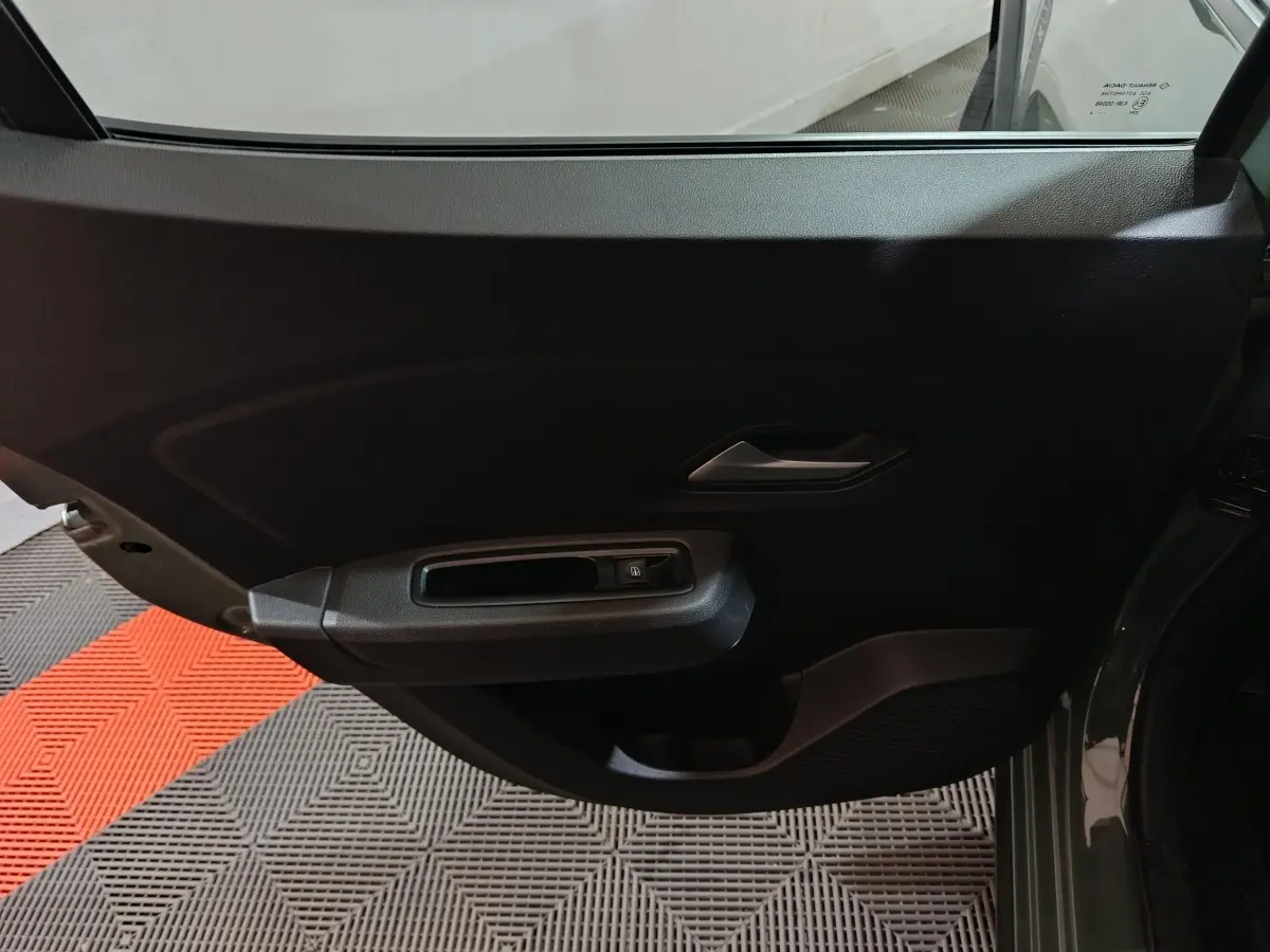 Vue intérieure de la porte arrière gauche de la Dacia Sandero Extreme+ TCe 110 2024 en vert, avec poignée et commande de vitre.