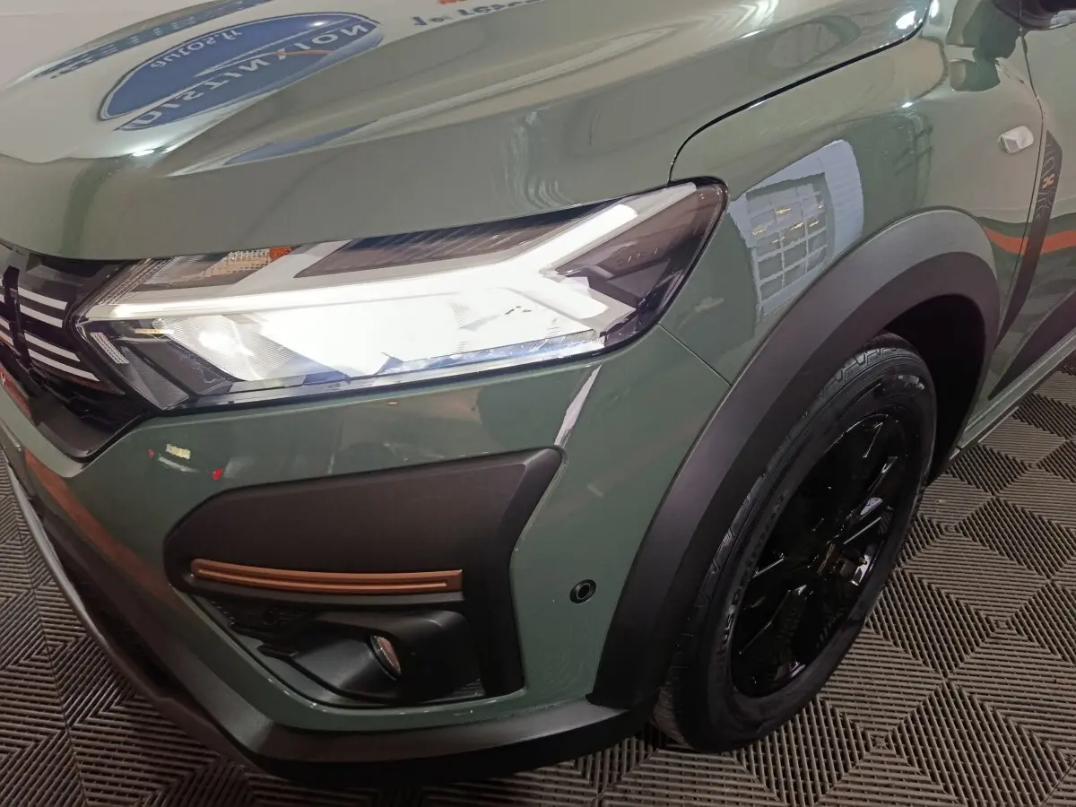 Gros plan sur l'avant droit vert d'une Dacia Sandero Extreme+ 2024 avec phares LED et jante noire.