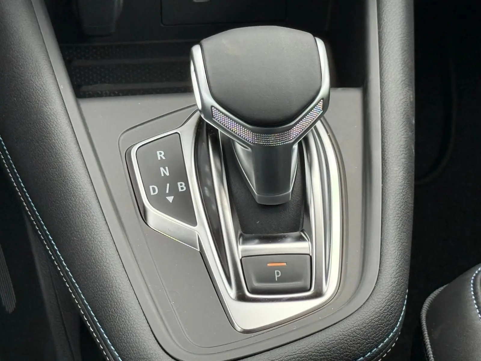 Le levier de vitesses noir et chrome de la Renault Symbioz 1.8 E-Tech Full Hybrid 160ch, vue rapprochée de la console centrale.
