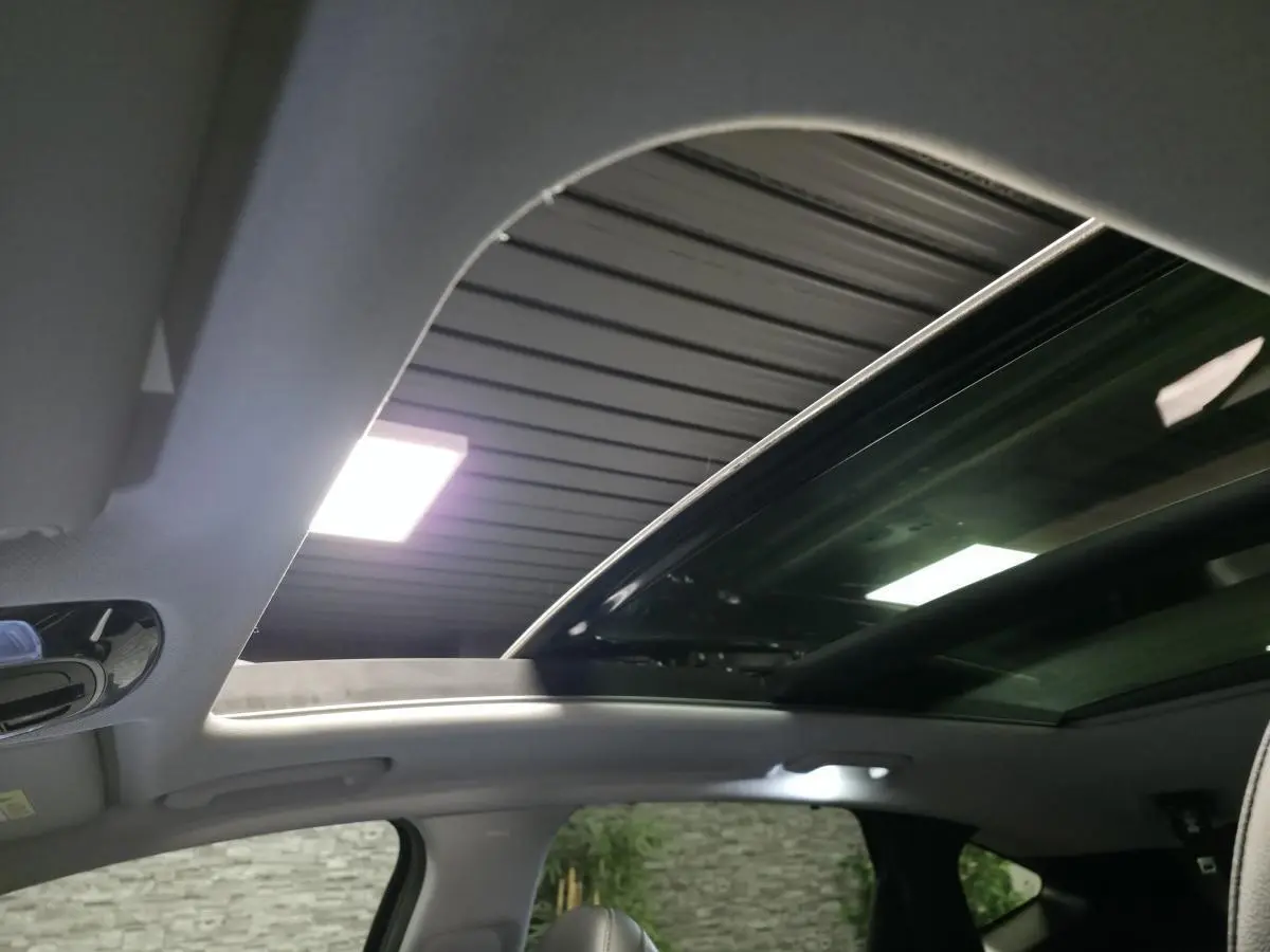 Toit ouvrant panoramique ouvert sur l'intérieur gris clair du Hyundai Tucson 2020, vue vers le ciel depuis l'habitacle.