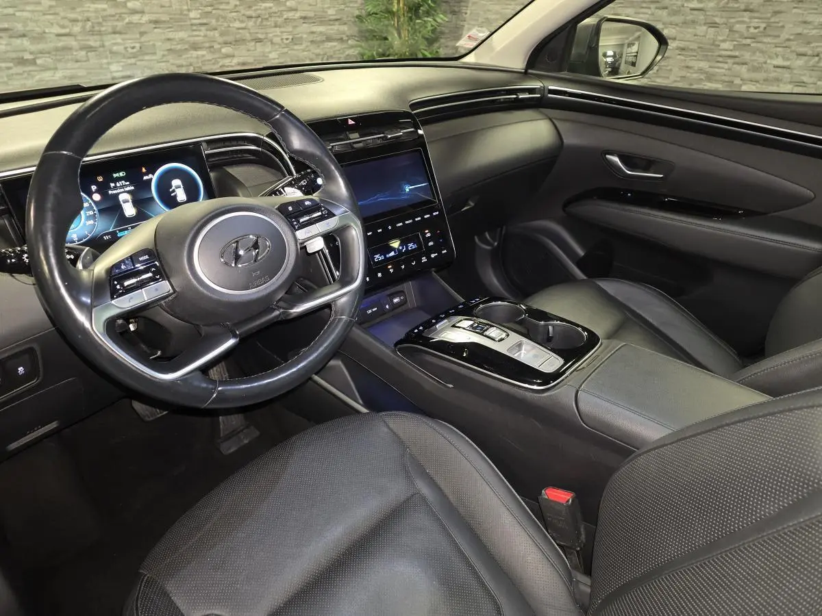Vue intérieure côté conducteur du Hyundai Tucson 2020, avec tableau de bord numérique et sellerie cuir noire.