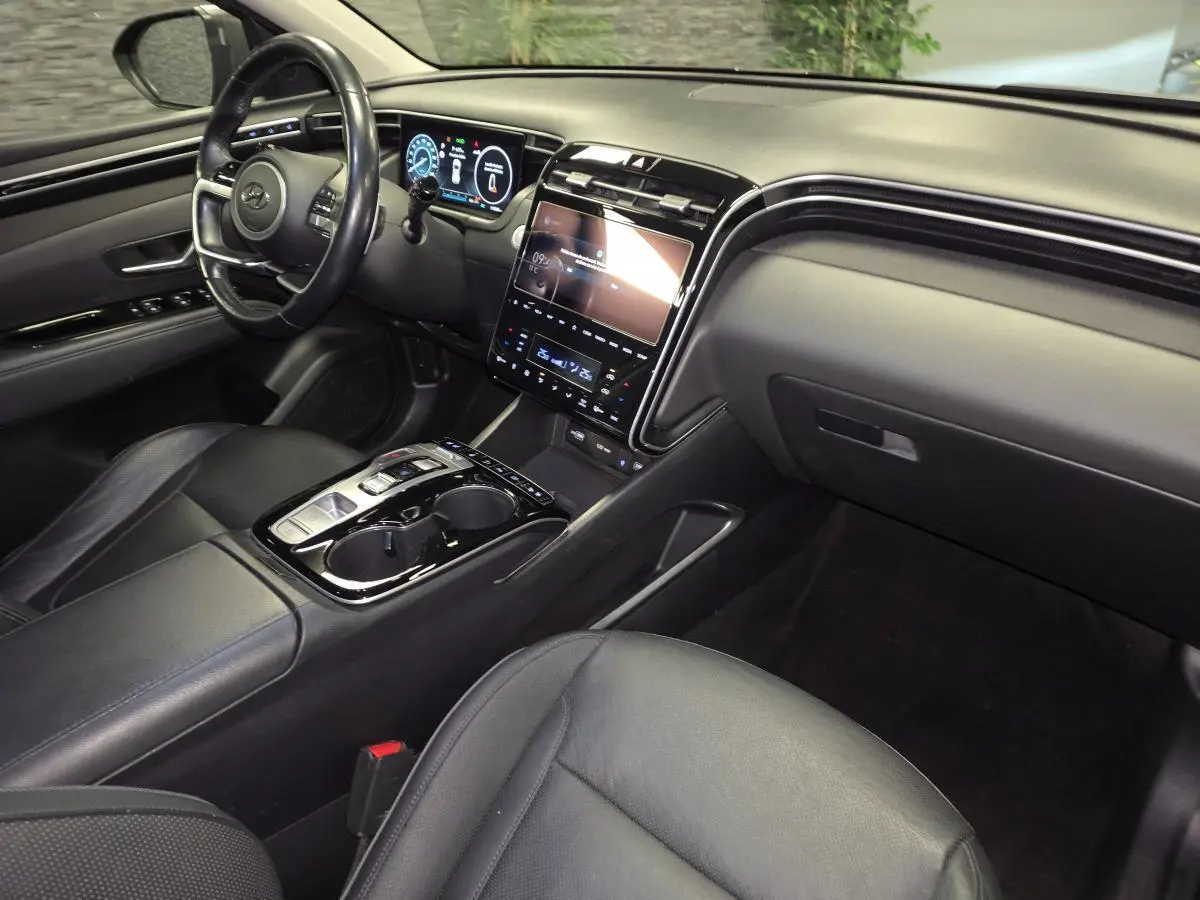 Vue intérieure côté passager du Hyundai Tucson gris 2020, mettant en valeur le tableau de bord numérique et la console centrale moderne.