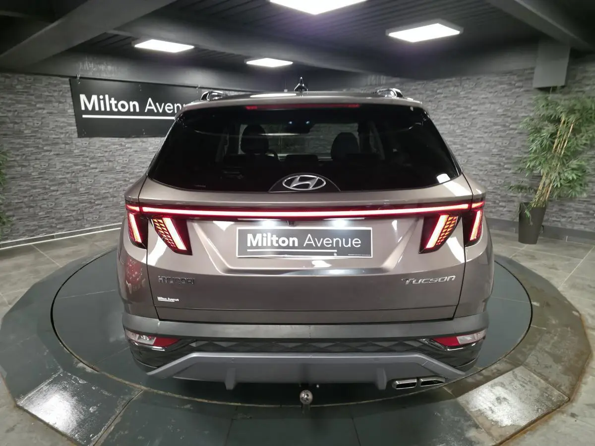 Vue arrière d'un Hyundai Tucson gris métallisé 2020 avec feux arrière LED en bandeau lumineux et double sortie d'échappement.