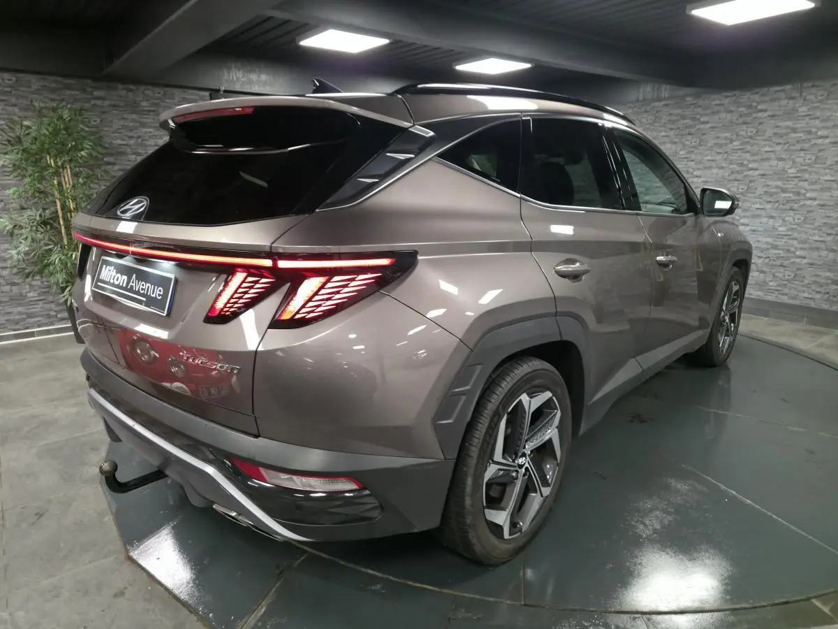 Vue 3/4 arrière droite du Hyundai Tucson gris métallisé avec feux arrière LED et jantes alliage 19 pouces.