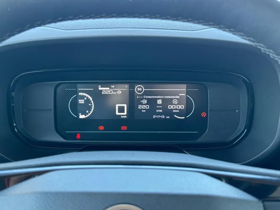 Vue rapprochée du tableau de bord numérique du Citroën Berlingo vert 2024, affichant la consommation instantanée et la vitesse.