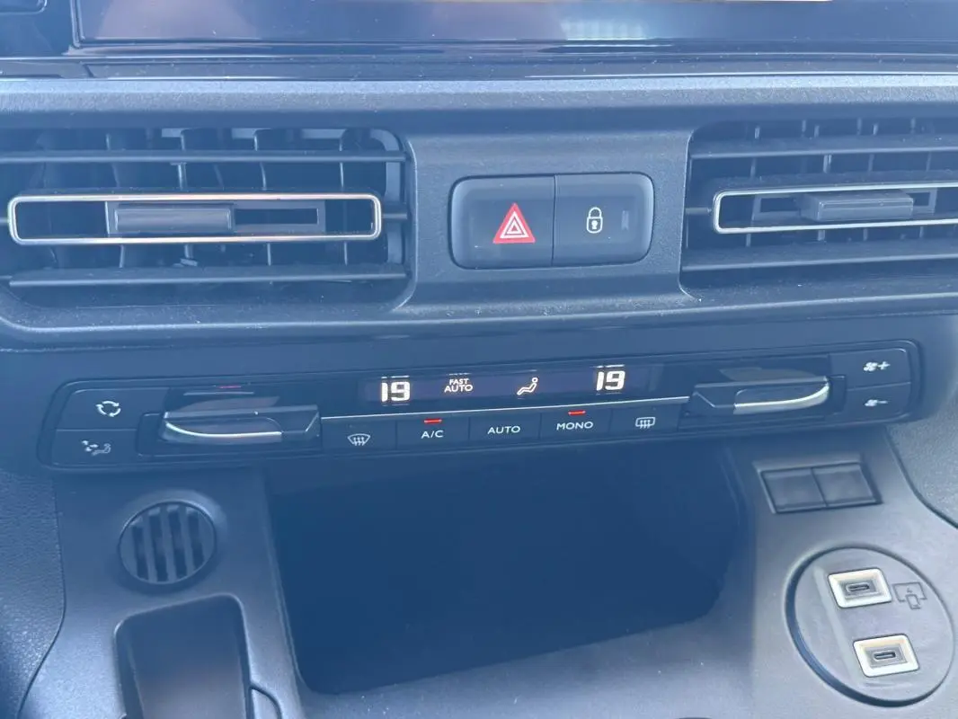 Vue rapprochée de la console centrale du Citroën Berlingo 2024, montrant la climatisation automatique et les ports USB.