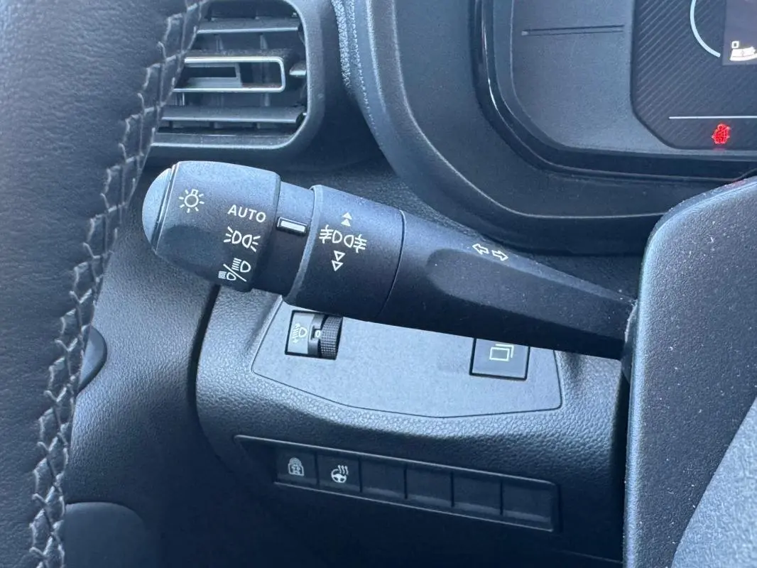 Gros plan sur la manette de commande des feux et clignotants du tableau de bord du Citroën Berlingo 2024.