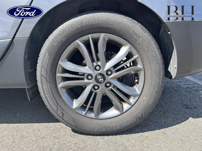 Gros plan sur la jante alu 16 pouces gris acier d'un Hyundai ix35 2014, avec logo Hyundai au centre.
