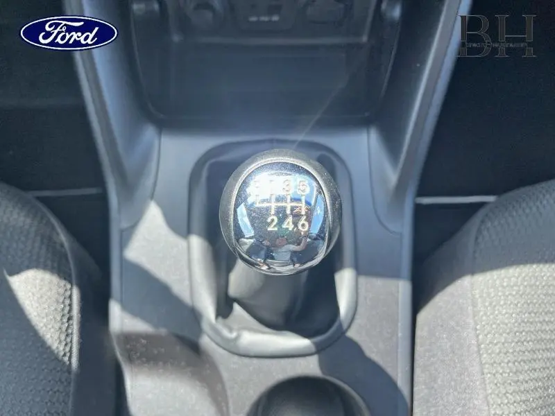 Gros plan sur le levier de vitesses manuel chromé d'une Hyundai ix35 gris acier, entouré de sièges en tissu noir.