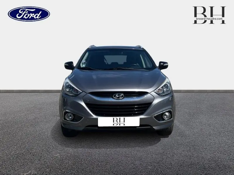 Vue avant d'un Hyundai ix35 1.6 GDI Pack Confort BlueDrive 2014 en gris acier avec phares halogènes et antibrouillard.