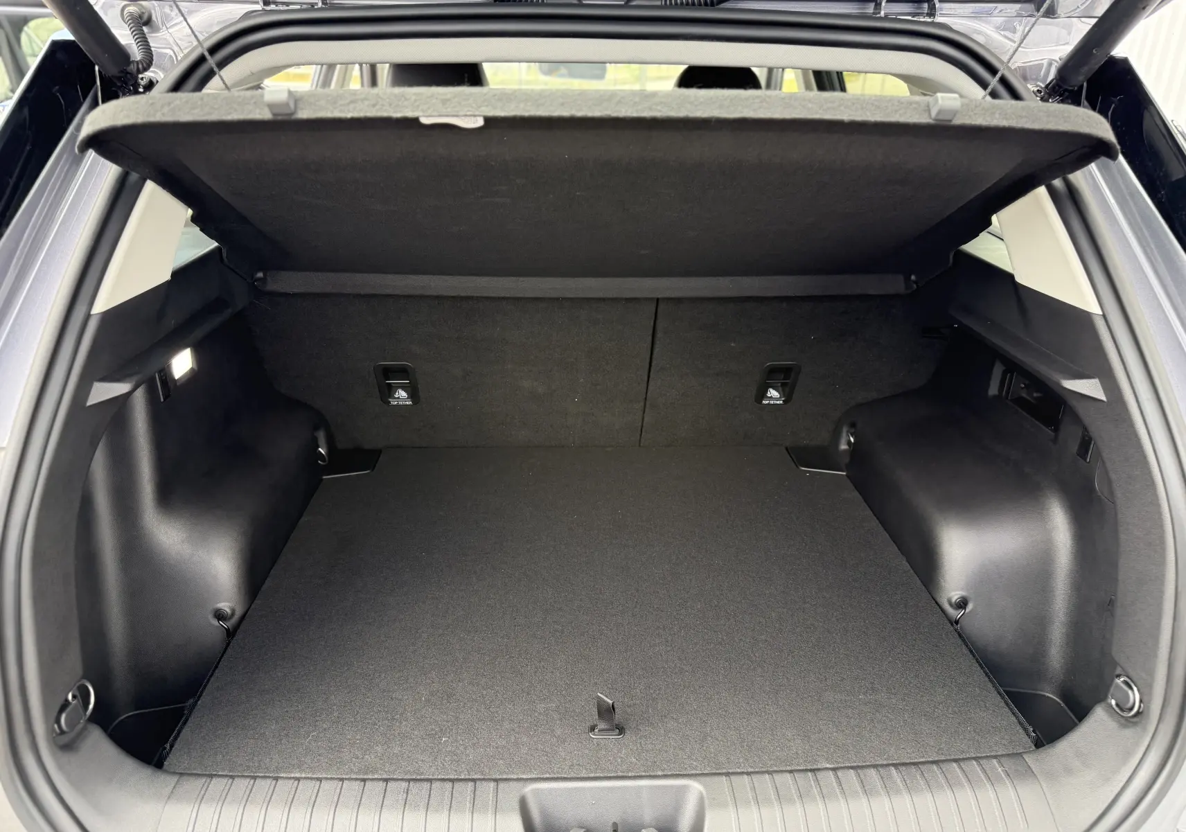 Coffre ouvert vu de l'arrière du JAECOO J5 2026 en Phantom Grey Metal, espace de chargement spacieux et tapis noir.