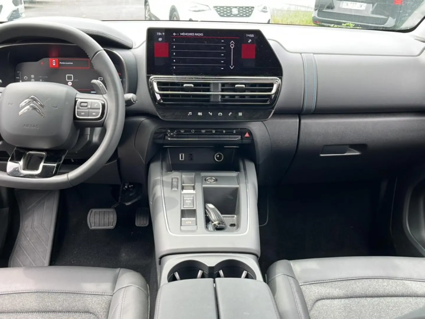 Vue intérieure avant du Citroën C5 Aircross 2025, tableau de bord et console centrale avec écran tactile et volant multifonction.