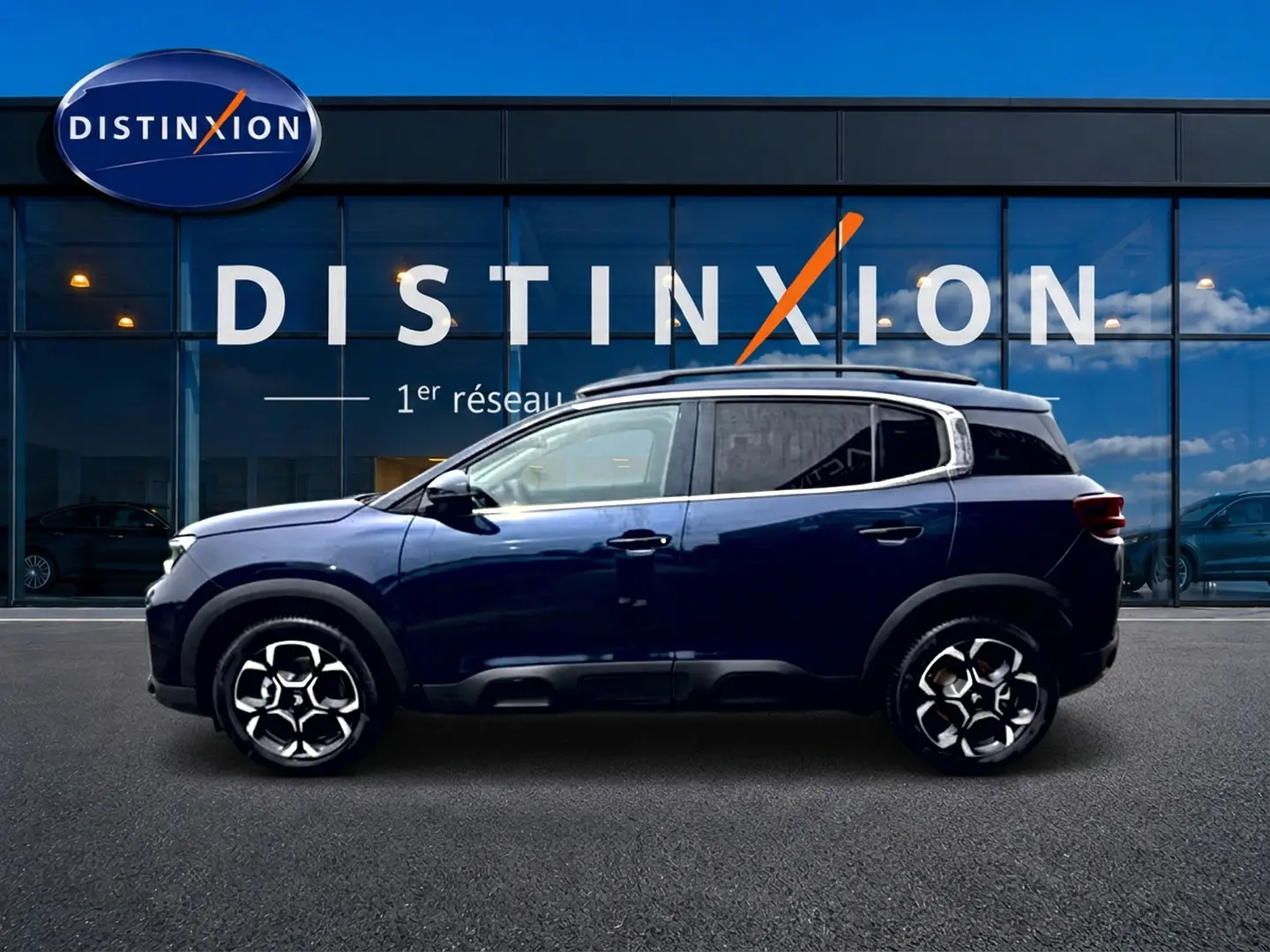 Profil côté gauche du Citroën C5 Aircross bleu eclipse 2025 avec jantes alu et barres de toit visibles.