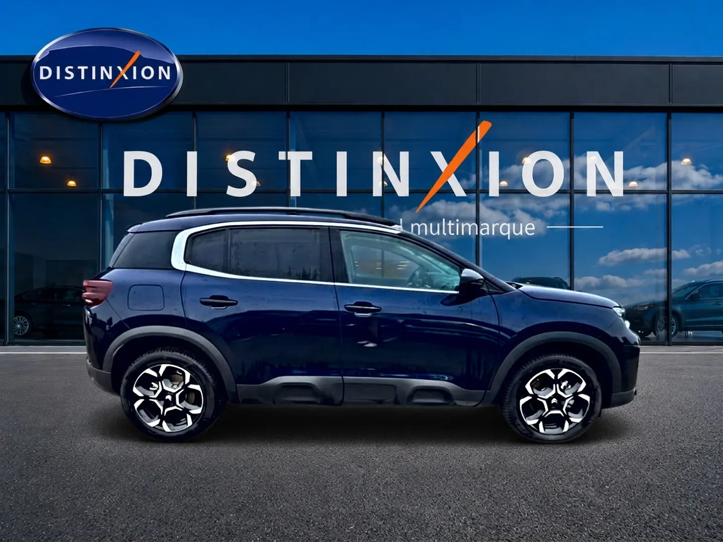 Vue latérale droite d'un Citroën C5 Aircross bleu eclipse 2025 avec jantes alu et barres de toit visibles.