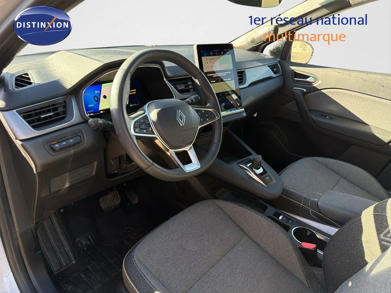Vue intérieure avant droite du Renault Symbioz 2025, volant cuir, tableau de bord numérique et écran tactile vertical.