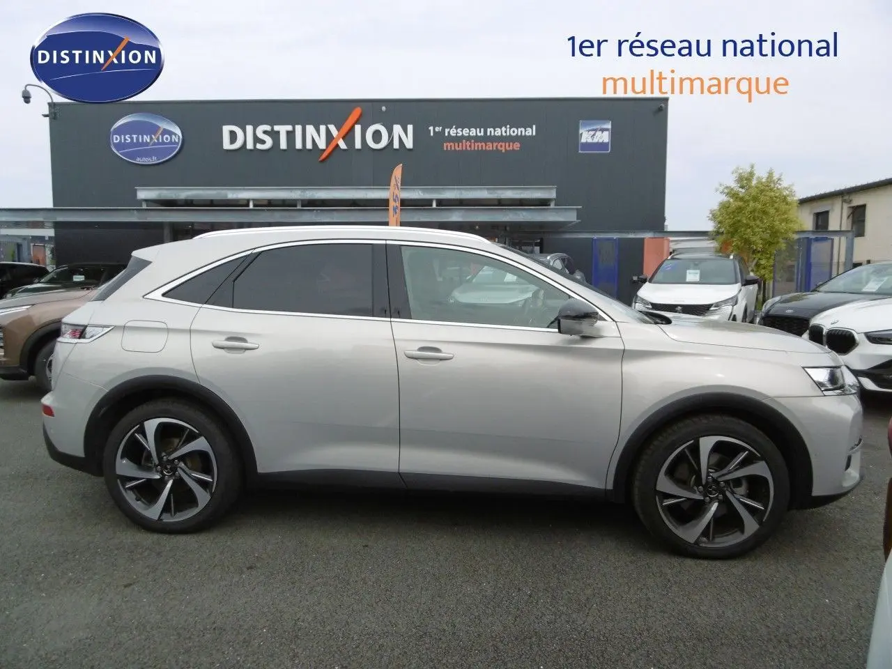 Profil côté droit du DS7 Crossback hybride rechargeable 2021 en Crystal Pearl, avec jantes alliage et vitres teintées.