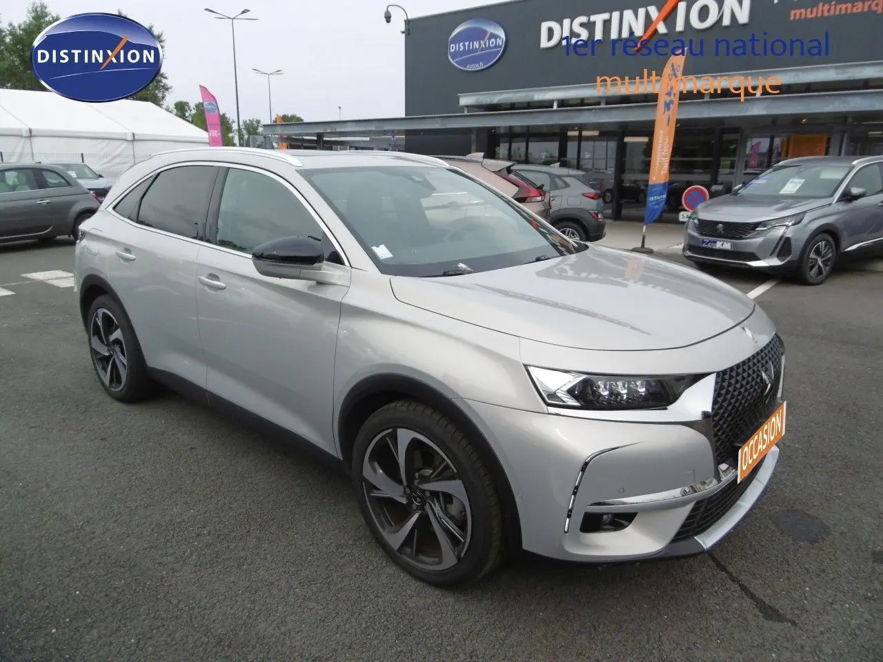 DS7 Crossback hybride rechargeable Crystal Pearl en 3/4 avant droit, avec jantes alliage et calandre distinctive.