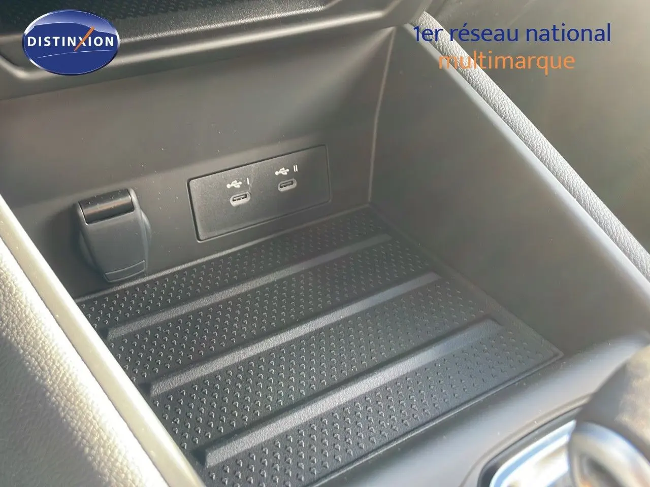 Prise USB double et prise 12V dans le rangement central noir du Renault Captur E-Tech hybride 2025.