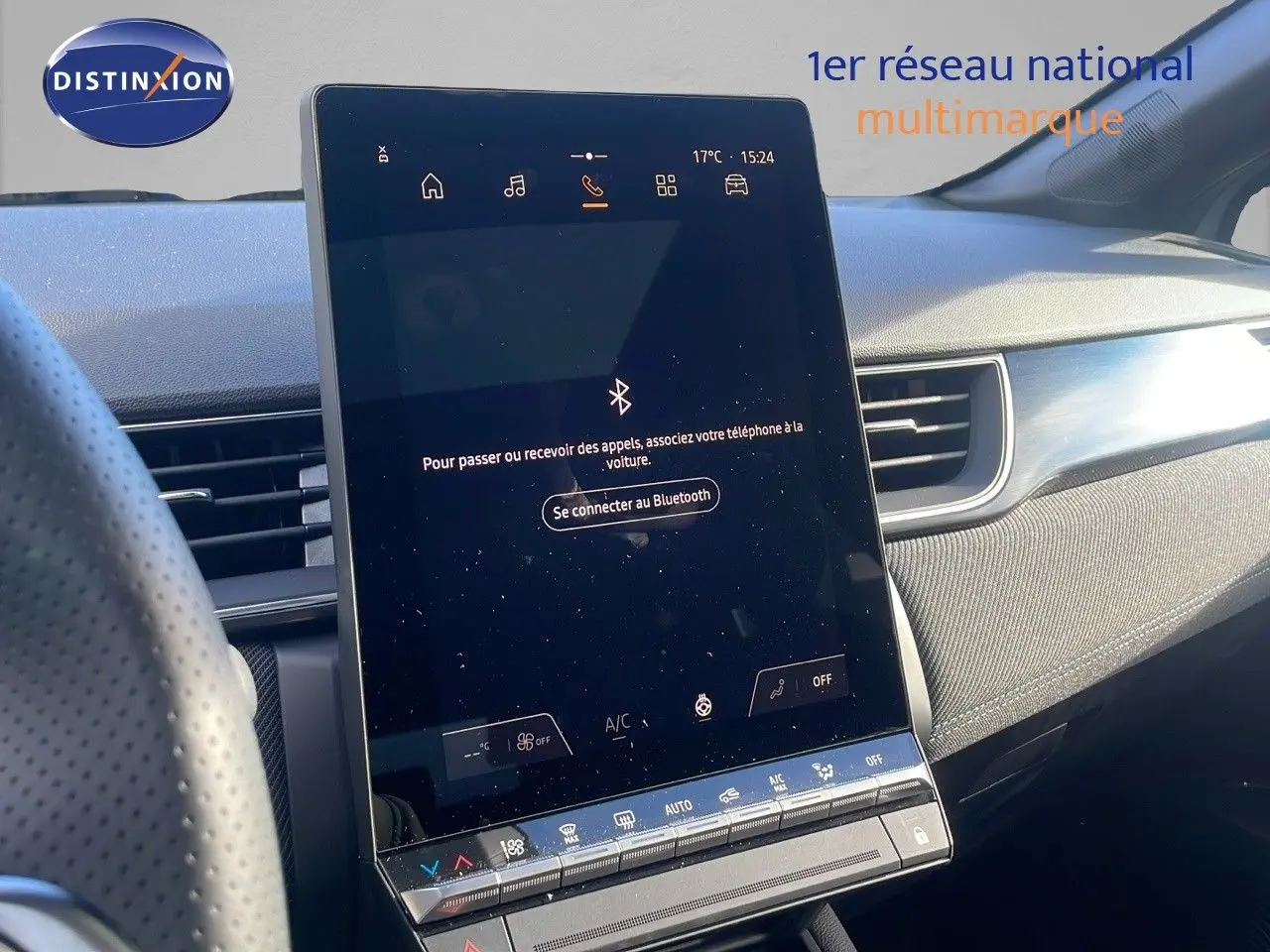 Vue intérieure du tableau de bord du Renault Captur E-Tech hybride 2025 avec écran tactile central vertical et garniture tissu gris.