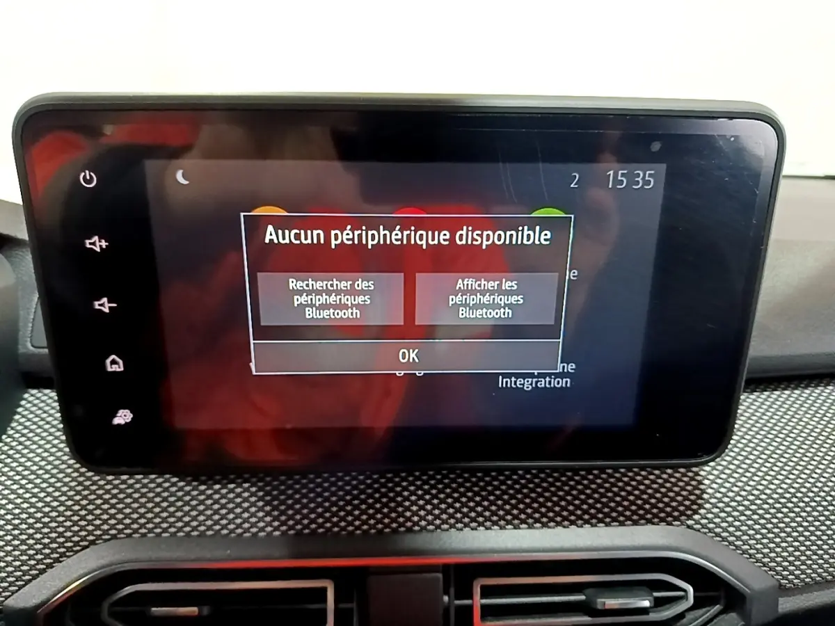 Écran tactile central du tableau de bord de la Dacia Sandero blanc, affichant un message Bluetooth.
