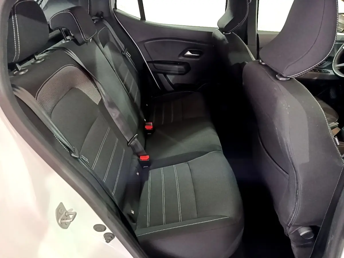 Vue intérieure côté gauche montrant la banquette arrière noire de la Dacia Sandero Confort TCe 90 blanche de 2022.