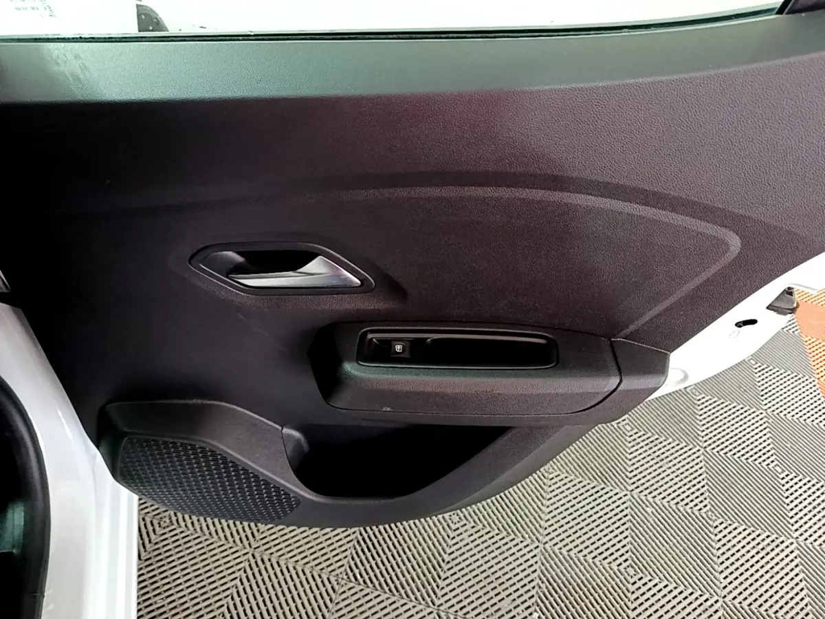 Vue rapprochée de la porte avant gauche noire d'une Dacia Sandero blanc 2022, avec poignée et commande de vitre électrique.