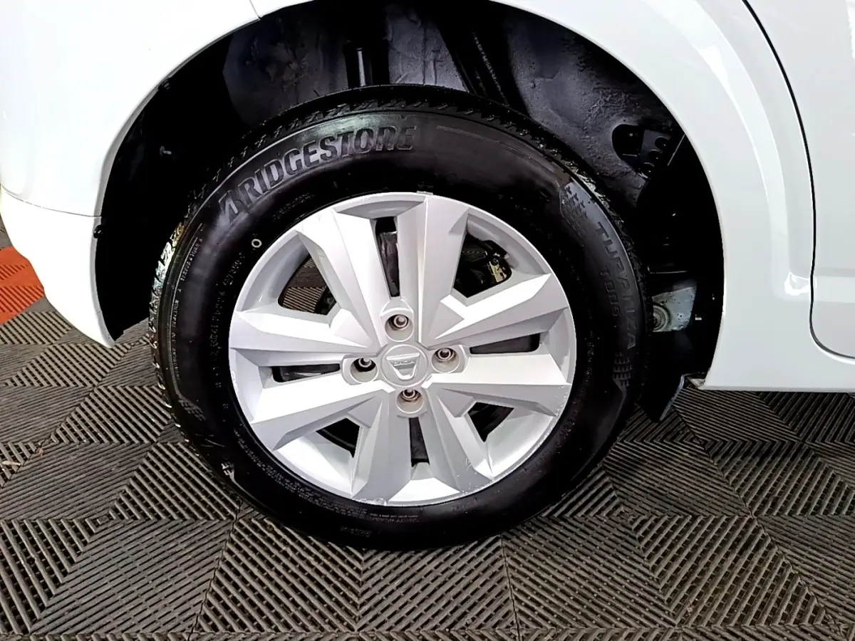 Gros plan sur la roue avant droite blanche d'une Dacia Sandero 2022 avec jante en alliage et pneu Bridgestone.