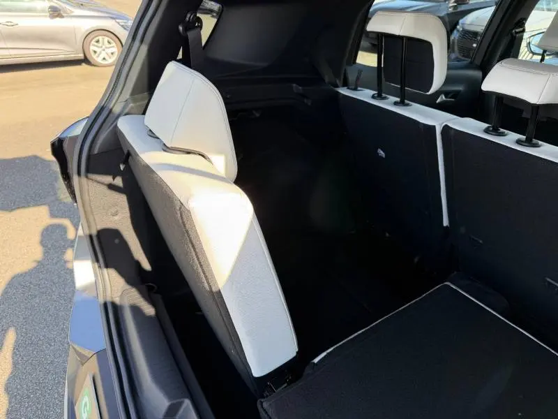 Vue arrière intérieure du Citroën C3 Aircross gris Mercury, montrant les sièges arrière rabattables et la troisième rangée partiellement déployée.