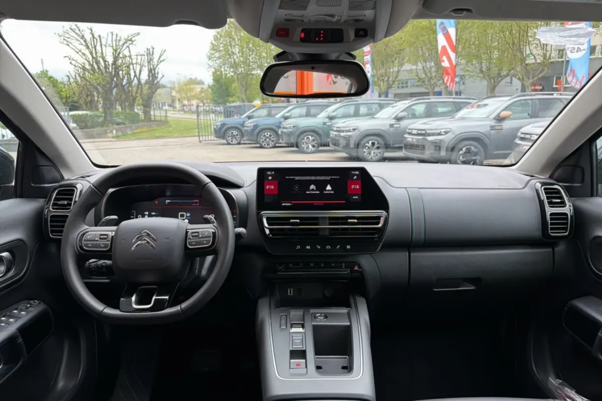 Vue intérieure de face du tableau de bord du Citroën C5 Aircross Hybrid 145 gris platinium avec écran tactile et volant multifonctions.