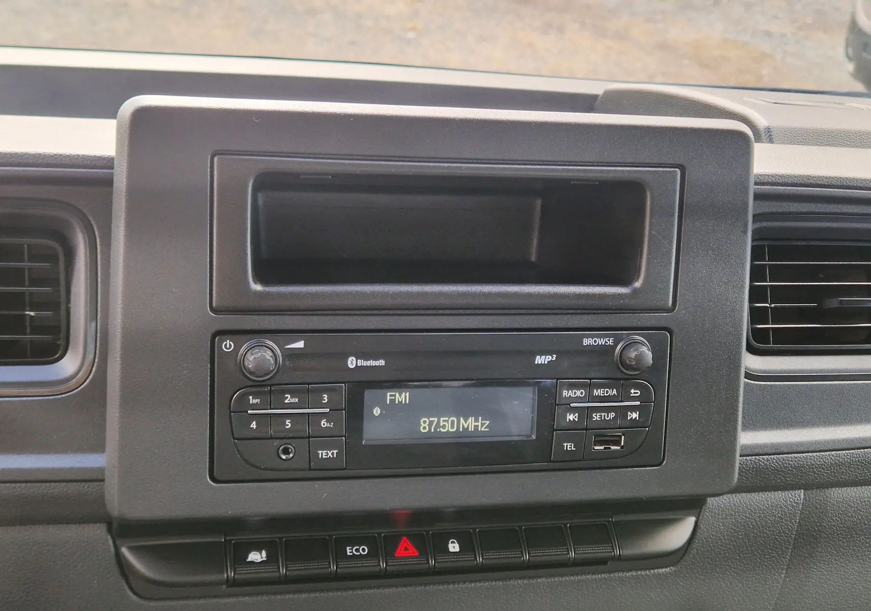 Vue rapprochée du tableau de bord noir du Renault Master Châssis Cabine 2024, avec radio et commandes centrales visibles.